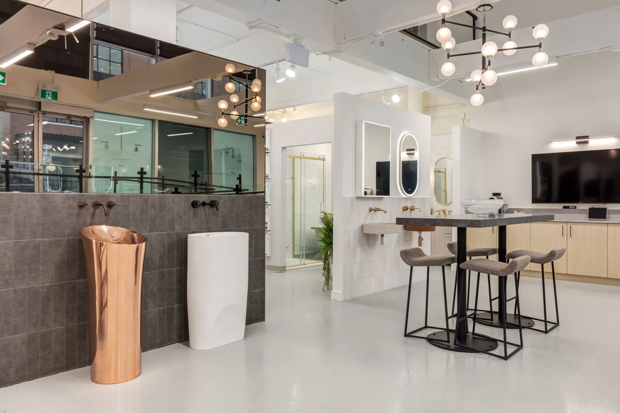 Baths by Design showroom interior with a copper pedestal sink and display vanities