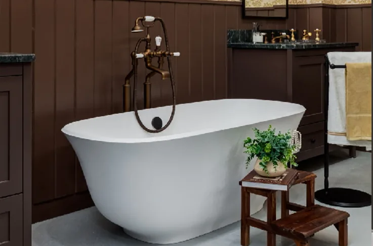 Freestanding roll-top tub with a floor-mounted tub filler in a panelled bathroom