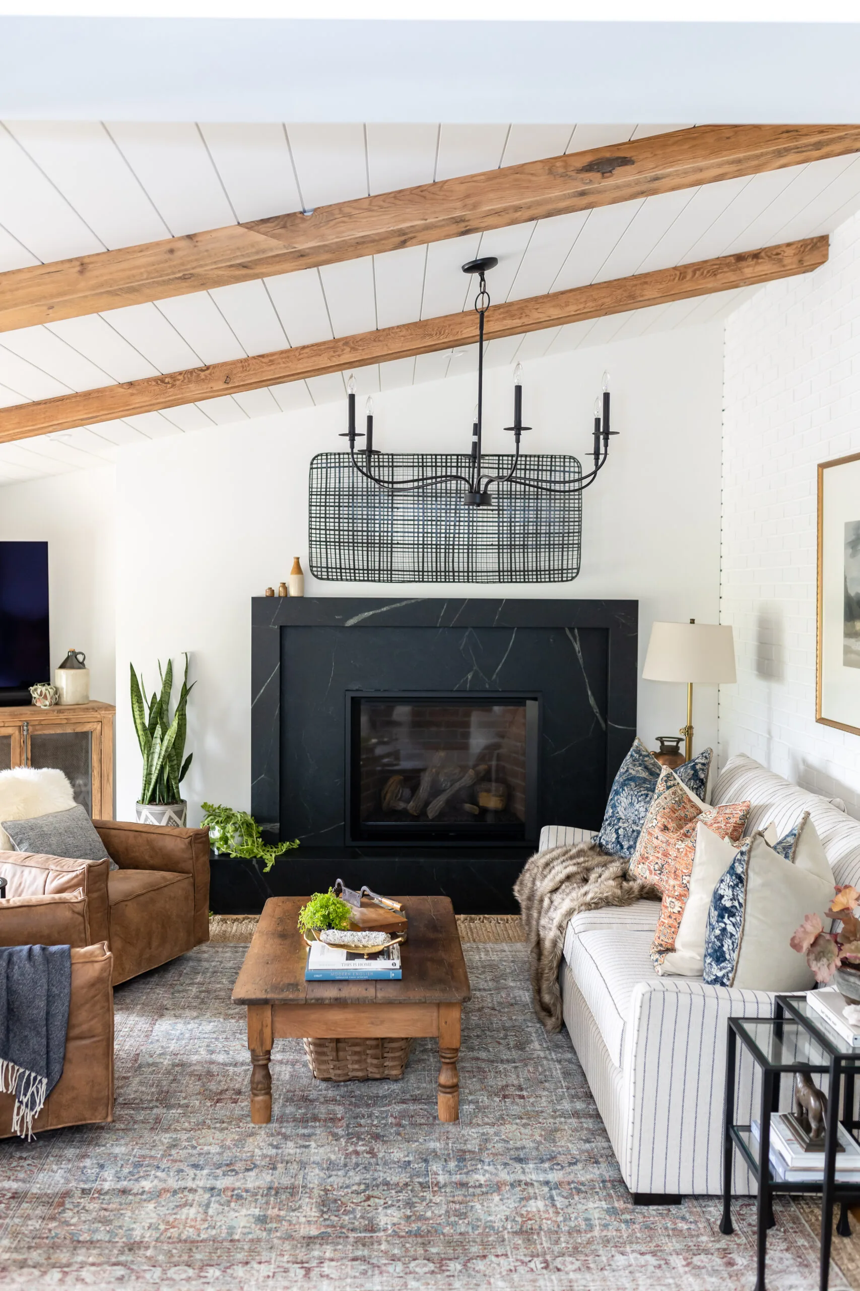 Living room with a black fireplace and wood-beamed ceiling in Carolyn Wilbrink's project
