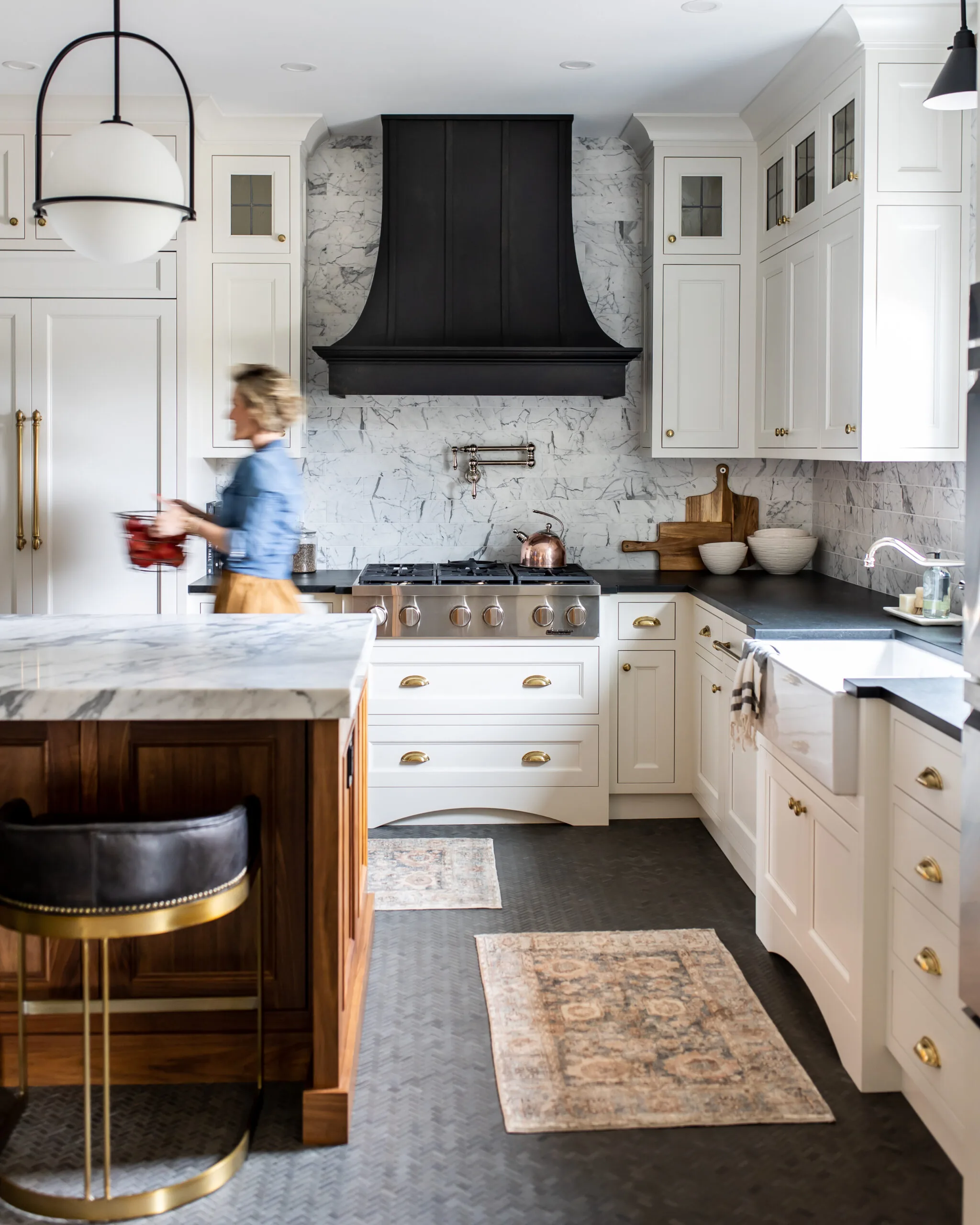 Farmhouse kitchen with a black range hood and marble island in Carolyn Wilbrink's project
